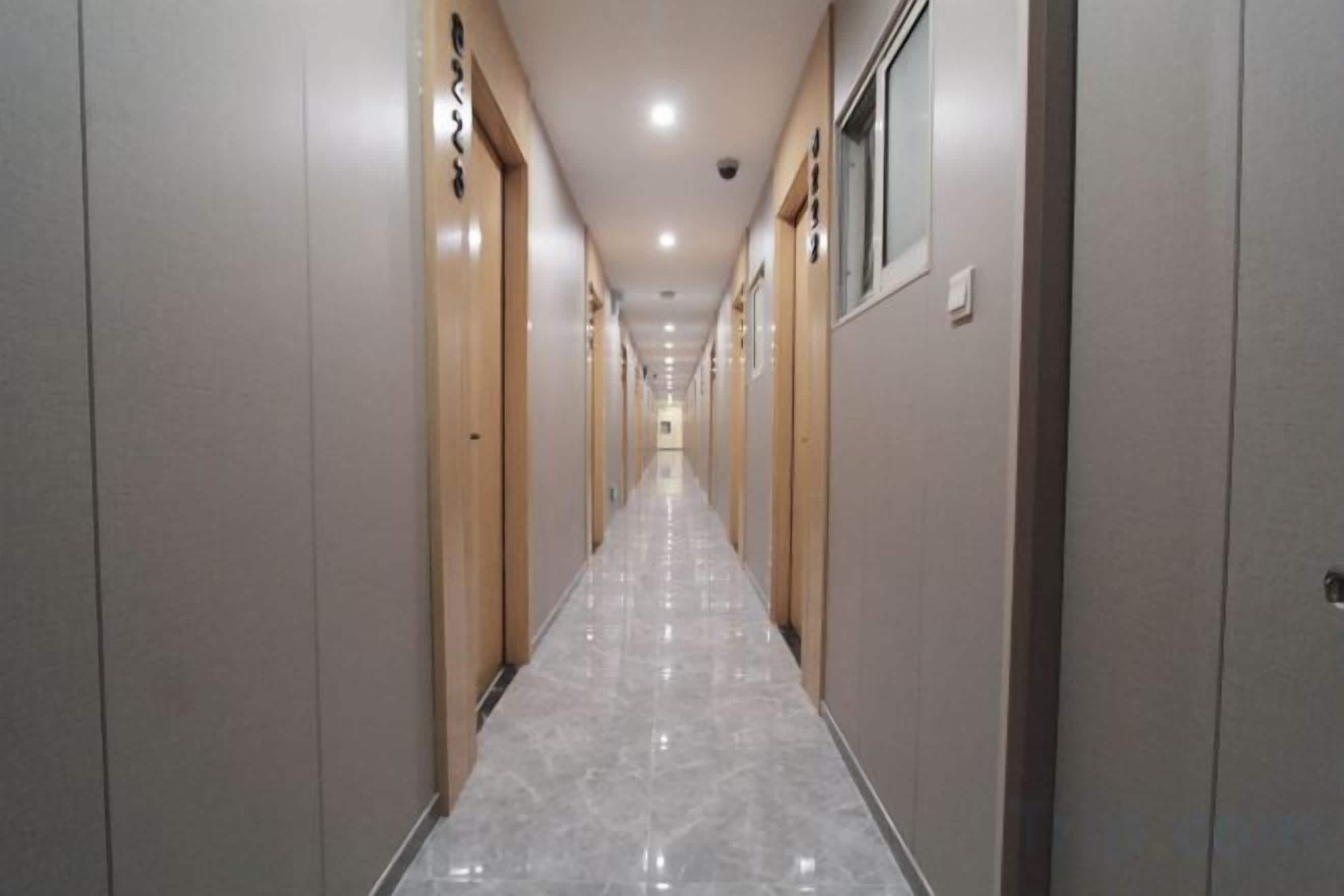 Un pasillo con puertas a ambos lados, que da acceso a habitaciones.