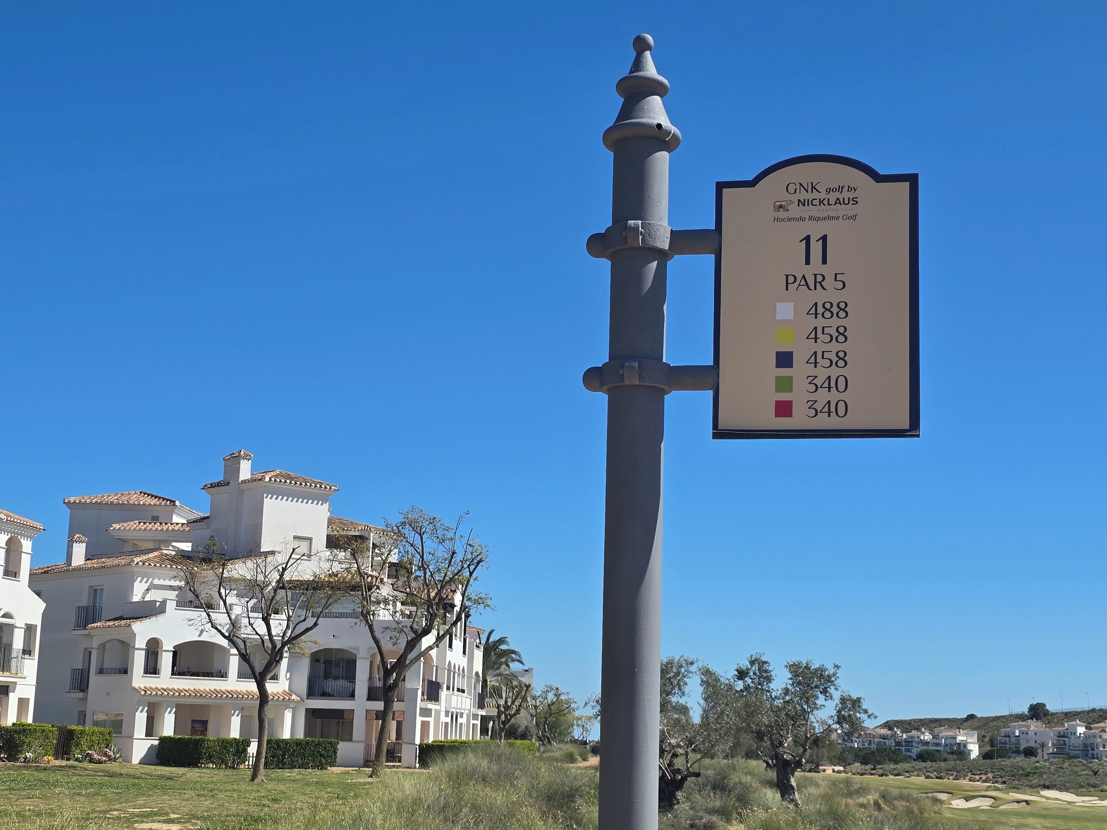 A golf course sign with hole numbers and distances.