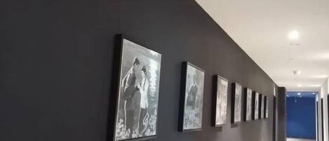 A hallway with framed photographs on the wall.