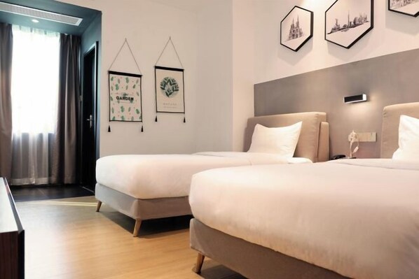 A hotel room with two beds, a desk, and framed pictures on the wall. - Waito Hotel (Guangzhou Kecun Metro Station Liying Plaza) (Guangzhou)