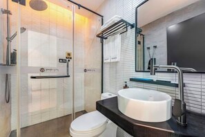 A modern bathroom with a white toilet, a large sink, and a glass shower enclosure. - Waito Hotel (Guangzhou Kecun Metro Station Liying Plaza) (Guangzhou)