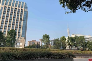 A tall building with a modern design, surrounded by trees and other buildings. - Waito Hotel (Guangzhou Kecun Metro Station Liying Plaza) (Guangzhou)