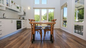 Eine moderne Küche mit weißen Schränken, einem Holztisch und vier Stühlen.