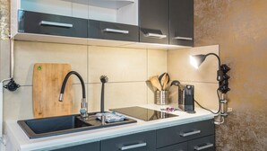 Una cocina moderna con pileta, encimera y alacenas.