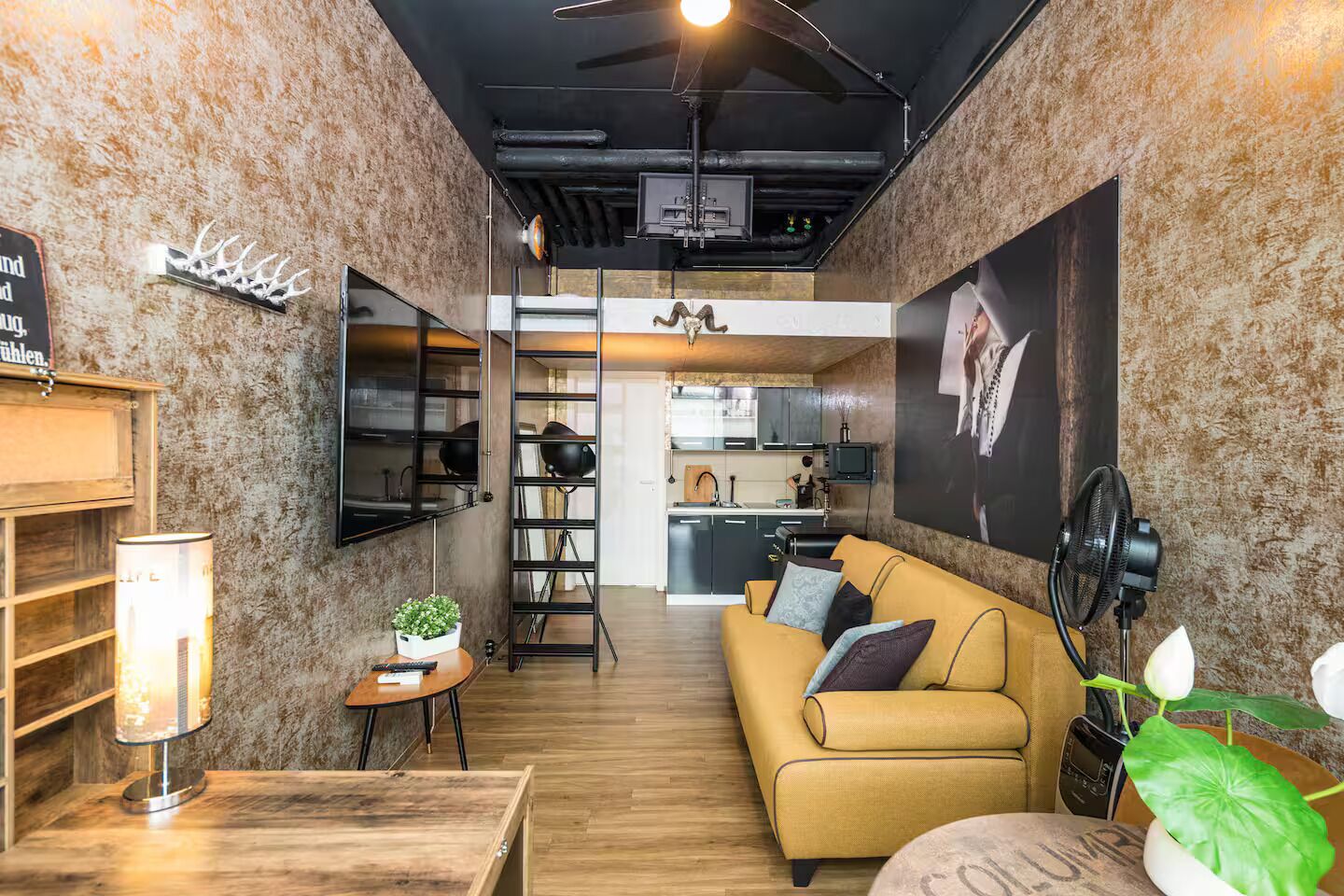 Ein gemütlicher Wohnbereich mit einer Couch, einem kleinen Tisch, einer Lampe und einer Pflanze.