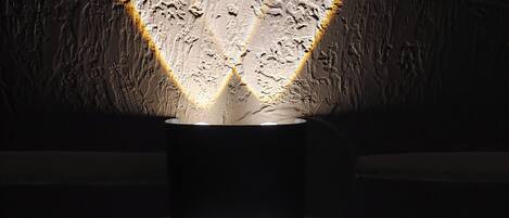 A textured wall with a central light fixture casting reflections.