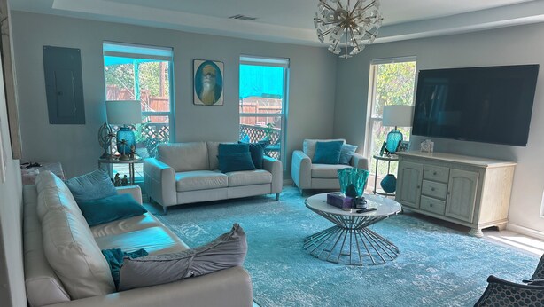A living room with two sofas, a coffee table, a TV, and a chandelier. - Serenity :3-bedroom bungalow in phenomenal Flower Mound with Wi Fi, AC, Parking (Flower Mound)