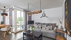 Ein modernes Wohnzimmer mit einer Couch, einem Couchtisch und einer Pendelleuchte.