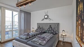 Ein modernes Schlafzimmer mit einem großen Bett, einem Deckenventilator und einem Stadtbild.