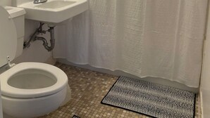 A bathroom with a toilet, sink, and shower curtain. - Trendy apartment in Gadsden, AL (Gadsden)