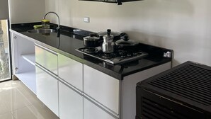 A modern kitchen with a black countertop, stainless steel appliances, and white cabinetry.