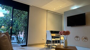 A modern living room with a sofa, a coffee table, and a TV mounted on the wall.
