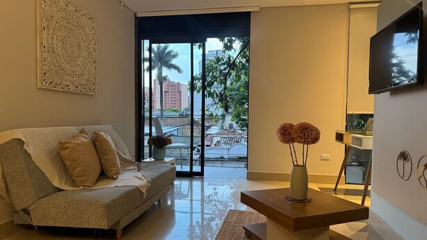 A modern living room with a sofa, a coffee table, and a TV mounted on the wall.