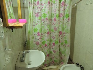 A bathroom with a sink, a mirror, a shower curtain with floral patterns, and a toilet. - San Francisco Cabins 1 (Las Vegas)