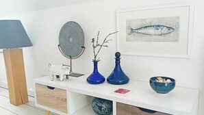 A white console table with a lamp, decorative items, and a framed fish painting. - Valley Lodge - UK49228 (Gunnislake)