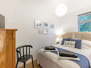 A bedroom with a bed, a desk, a chair, and wall art. - Valley Lodge - UK49228 (Gunnislake)