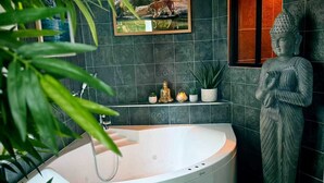 A modern bathroom with a freestanding bathtub, a Buddha statue, and a framed picture of a tiger. - Unusual escape to the heart of the jungle/Private spa/Cinema screen/10 min center (Amiens)