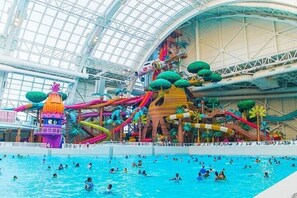 An indoor water park with a large pool, slides, and a climbing structure. - Luxury Urban Loft 3Bed|2BA nearNYC MetLife+Parking (Jersey City)