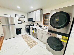Una cocina moderna con electrodomésticos de acero inoxidable, lavavajillas y horno empotrado.