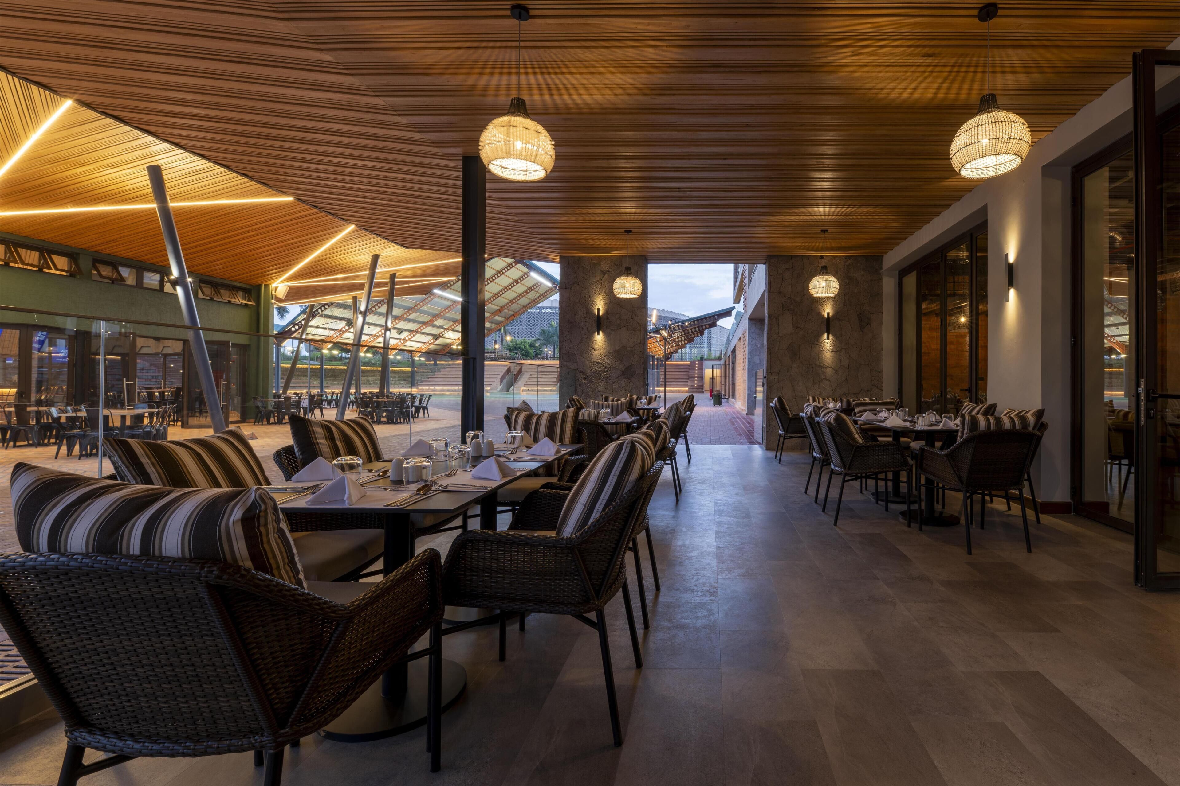 A restaurant with a long dining area, wicker chairs, and tables set for service.