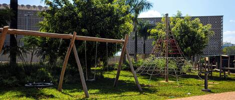 A playground with swings and a climbing structure.