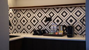 A kitchen with a patterned backsplash, a coffee machine, and a coffee maker on the counter.