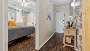 A bedroom with a bed, a ceiling fan, and a bedside table with a lamp.