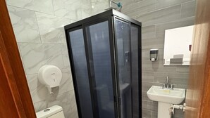 A bathroom with a toilet, a sink, and a shower enclosure. - Residencial Gran Cobae Dúplex A (Tonalá)