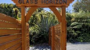 A wooden archway with the inscription "GLASS HORIZON" leading into a garden area. - Glass Horizon - Rutherglen Holiday Home (Ruthherglen)