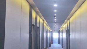 A long, narrow hallway with doors on both sides, recessed lighting, and a carpeted floor. - Juya Business Hotel (Shanghai)