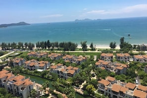 A coastal residential area with houses, a beach, and a clear view of the ocean.