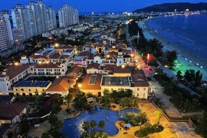 A coastal hotel with multiple buildings, a swimming pool, and a beach view. - Shuangyue Bay Vanke Scenic Apartment Villa Guesthouse (Huidong)