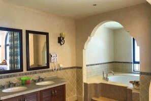 A bathroom with two sinks, a bathtub, and a large mirror. - Shuangyue Bay Vanke Scenic Apartment Villa Guesthouse (Huidong)