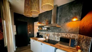 Une cuisine moderne avec un plan de travail en bois, des armoires blanches et un réfrigérateur encastré.