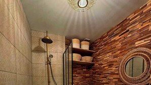 Une salle de bain moderne avec une baignoire sur pieds, un miroir rond et un décor mural en bois.