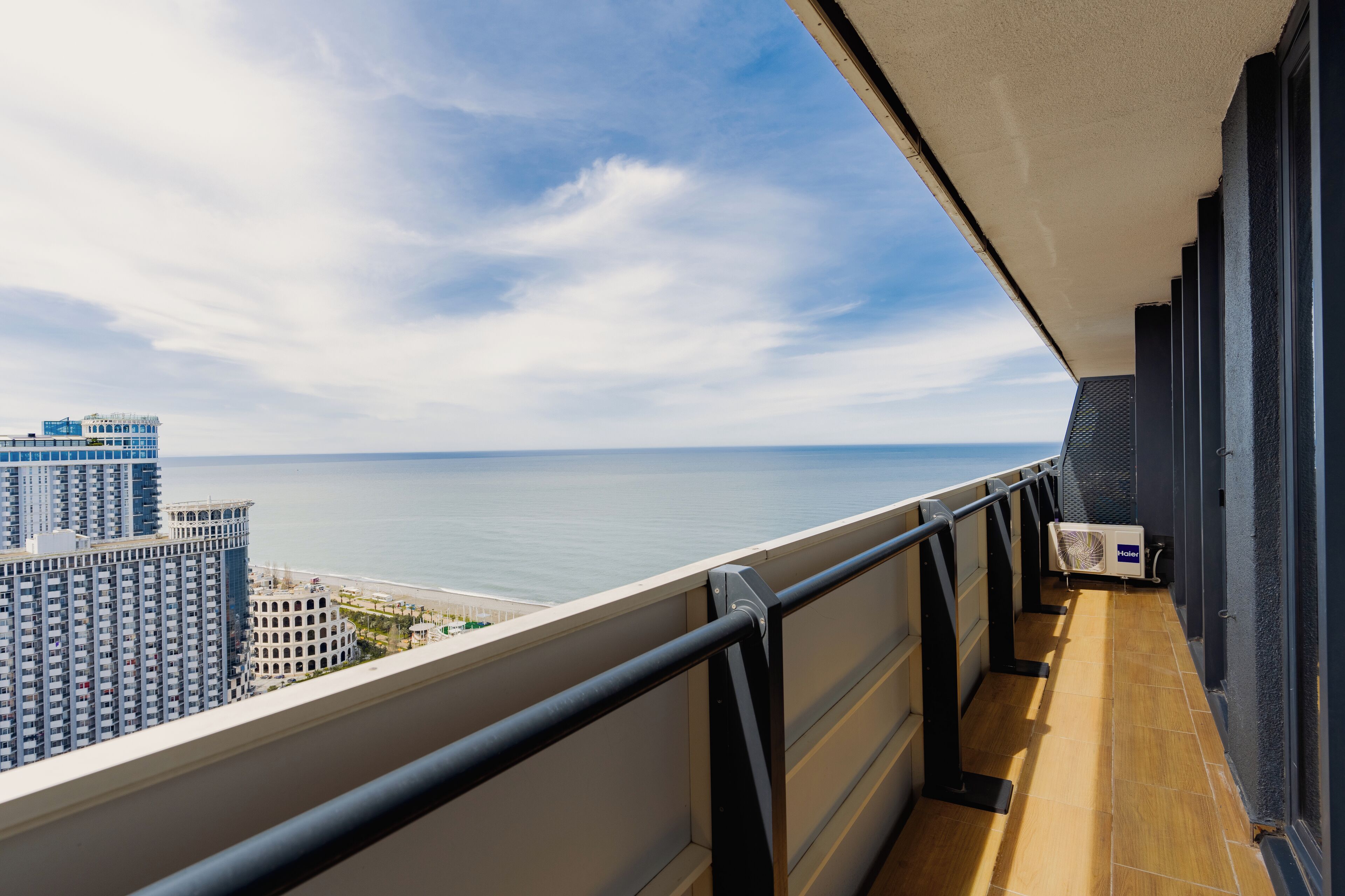 A balcony with a view of the sea and buildings.