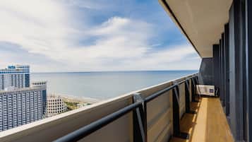 Un balcón con vista al mar y edificios.
