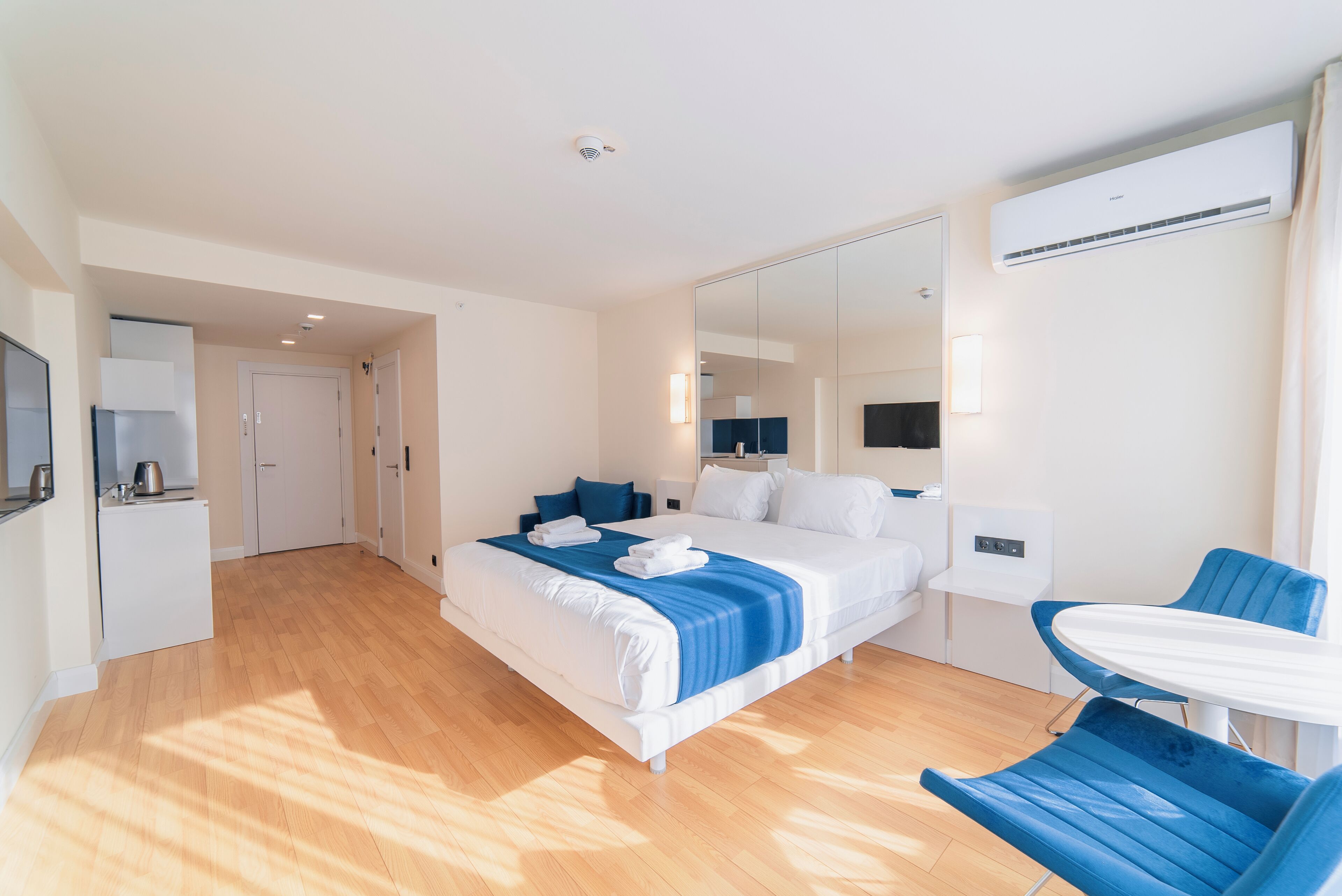 Een moderne hotelkamer met een groot bed, een tafeltje en een spiegel.