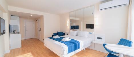 Een moderne hotelkamer met een groot bed, een tafeltje en een spiegel.
