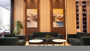 A lobby with two sofas, a coffee table, and a bookshelf. - IU Hotel (Chongqing Nanping Wanda Plaza Light Rail Station) (Chongqing)