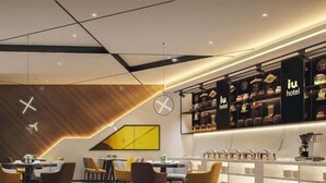 A modern hotel lobby with a central seating area, a coffee bar, and a wall with framed items. - IU Hotel (Chongqing Nanping Wanda Plaza Light Rail Station) (Chongqing)