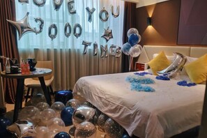 Een hotelkamer met een bed, een ronde tafel en een raam met gordijnen.