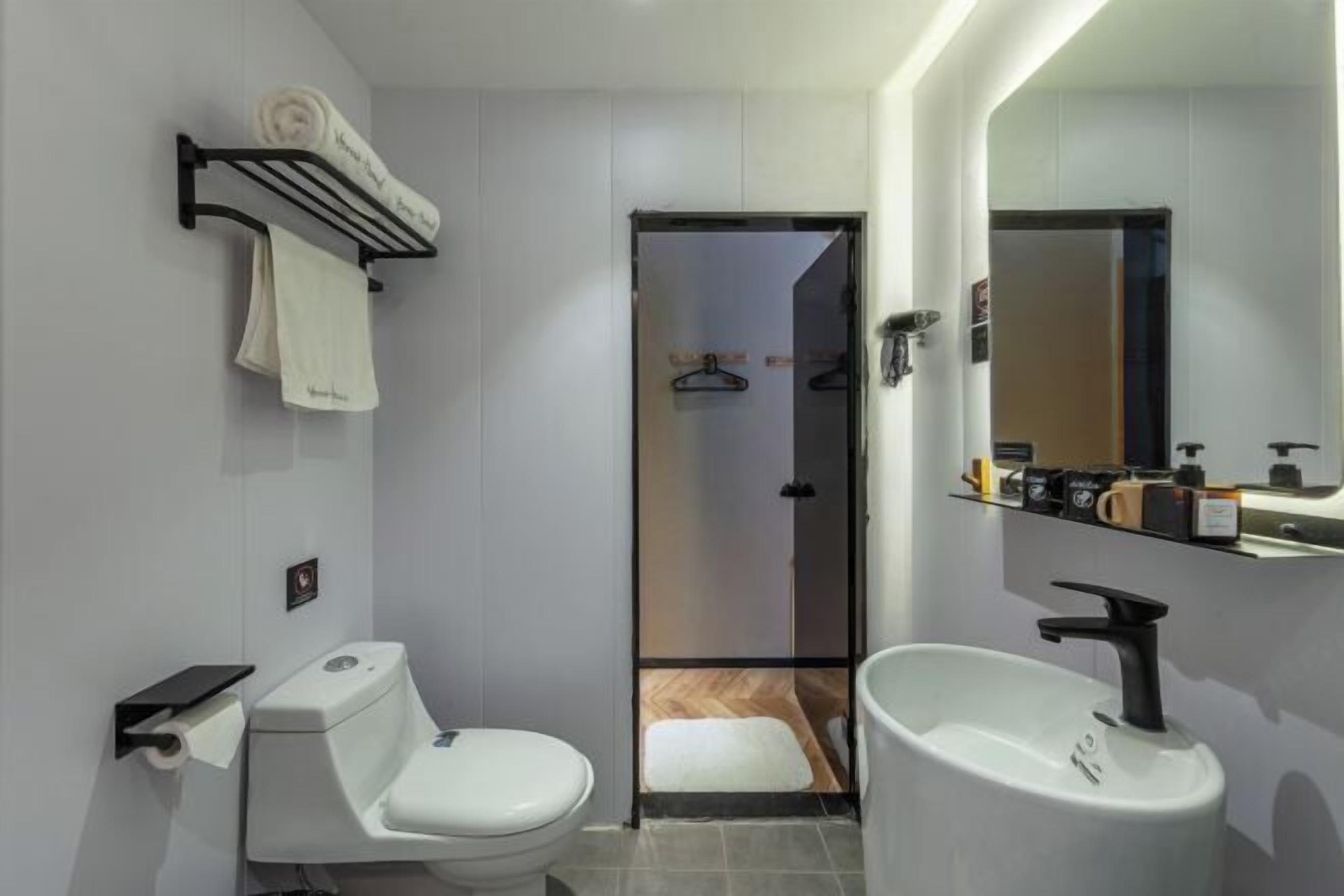 Un baño moderno con inodoro, lavamanos y toallero.