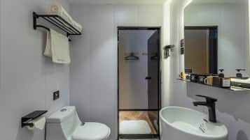 Un baño moderno con inodoro, lavamanos y toallero.