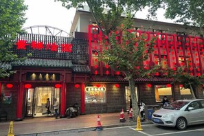 A traditional Chinese building with a red and black facade, a signboard with Chinese characters, and a visible entrance. - Zhengzhou Xinyang Lingrui Building Hotel (Provincial People's Hospital Metro Station) (Zhengzhou)