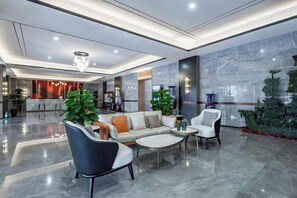A modern lobby with a sofa, chairs, and a coffee table.