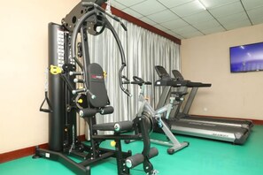 A gym with exercise equipment, a treadmill, and a television on the wall. - Zhengzhou Xinyang Lingrui Building Hotel (Provincial People's Hospital Metro Station) (Zhengzhou)