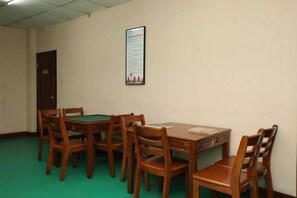 A room with a green carpet, wooden furniture, and a bulletin board on the wall. - Zhengzhou Xinyang Lingrui Building Hotel (Provincial People's Hospital Metro Station) (Zhengzhou)