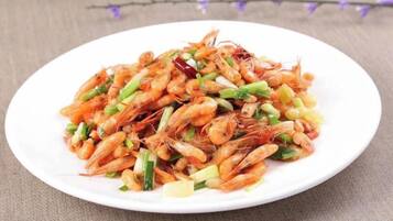 A plate of cooked shrimp with vegetables.