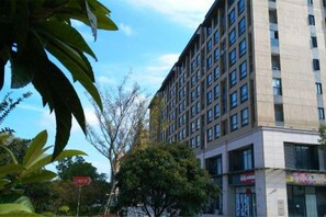 Un edificio de varios pisos con un diseño arquitectónico moderno, que presenta una serie de ventanas y balcones.